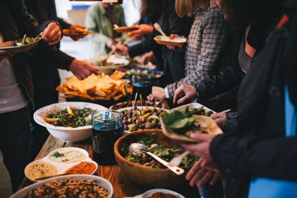 People by a banquet table full with food Stock Free