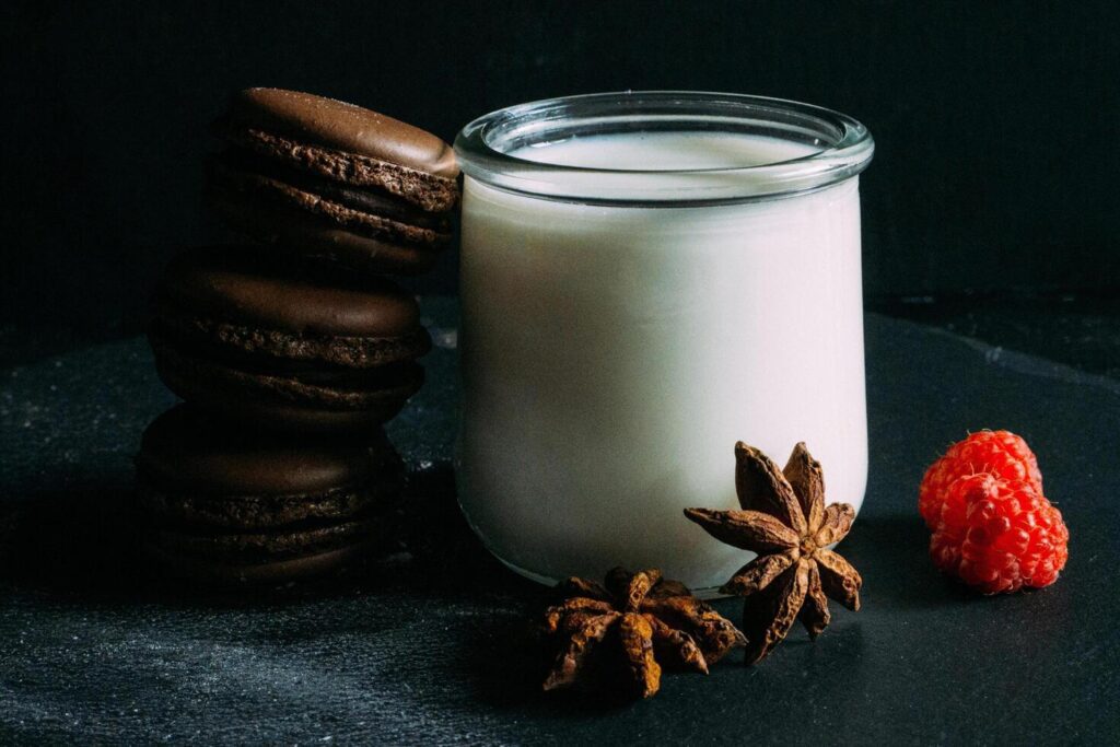 a glass jar with chocolate and macaroons on a black background Stock Free