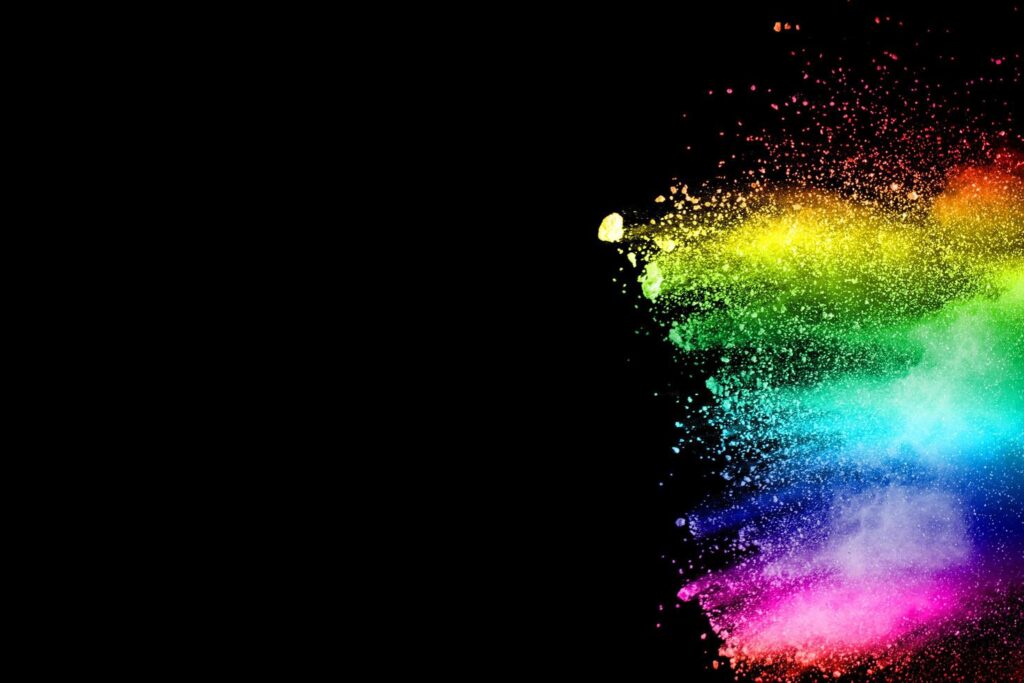 Abstract multicolored powder explosion on black background. Color dust particle splattered on background. Stock Free