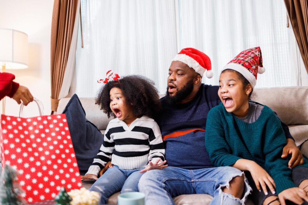 African American family surprised with a gift on Christmas day. Merry Christmas. Stock Free