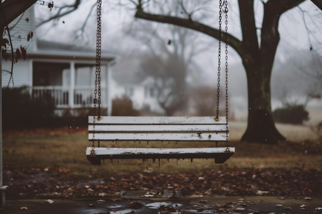 Empty wooden swing in the park on a rainy day Free Photo