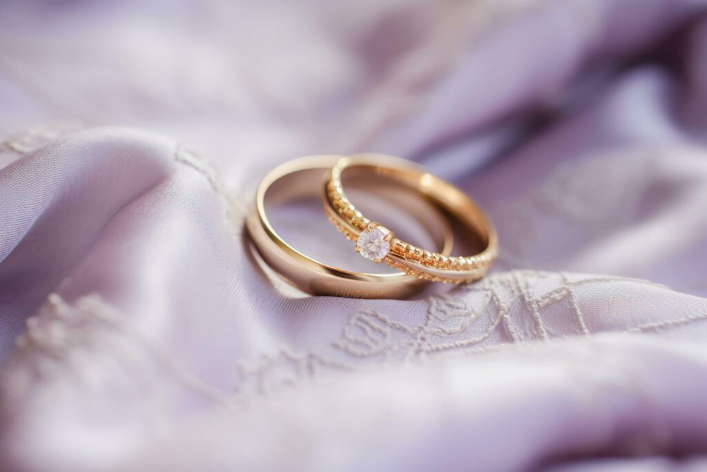 Lilac Love Wedding Rings Resting on Soft Fabric Free Photo