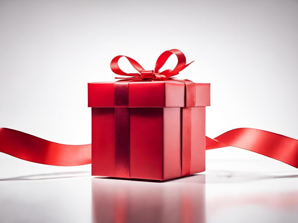 Red gift box with red ribbon on white background. Free Photo