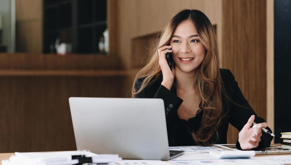 Asian business woman have the joy of talking on the phone, laptop and tablet on the office desk. Stock Free