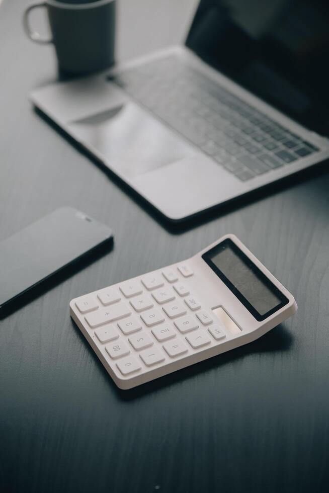 Asian Business woman using calculator and laptop for doing math finance on an office desk, tax, report, accounting, statistics, and analytical research concept Stock Free