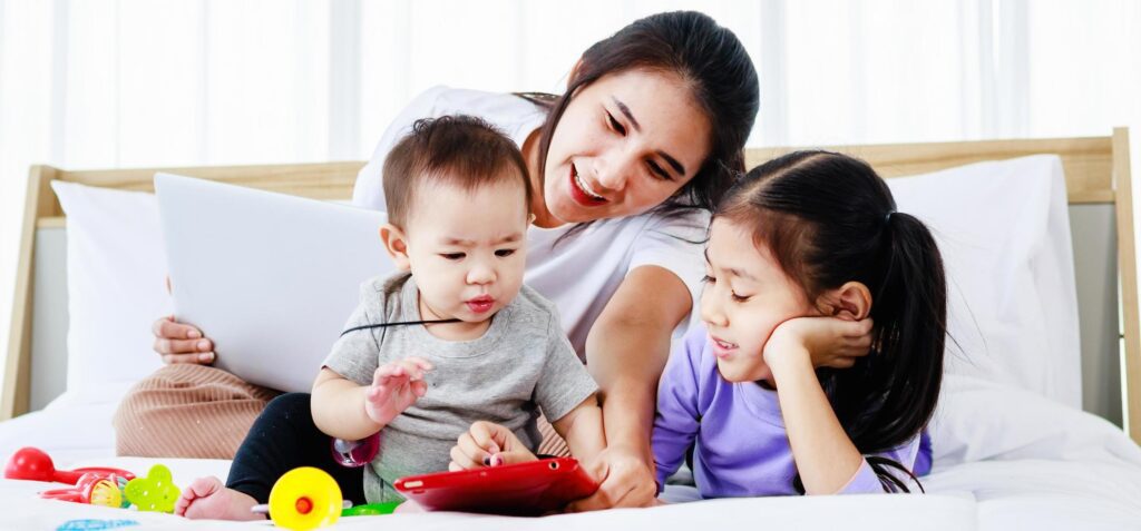 Asian Young mother on maternity leave trying to freelance with toddler child Stock Free