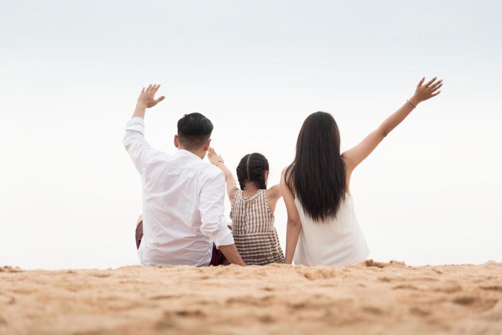 Back view of a happy family on beach at the sunset Stock Free