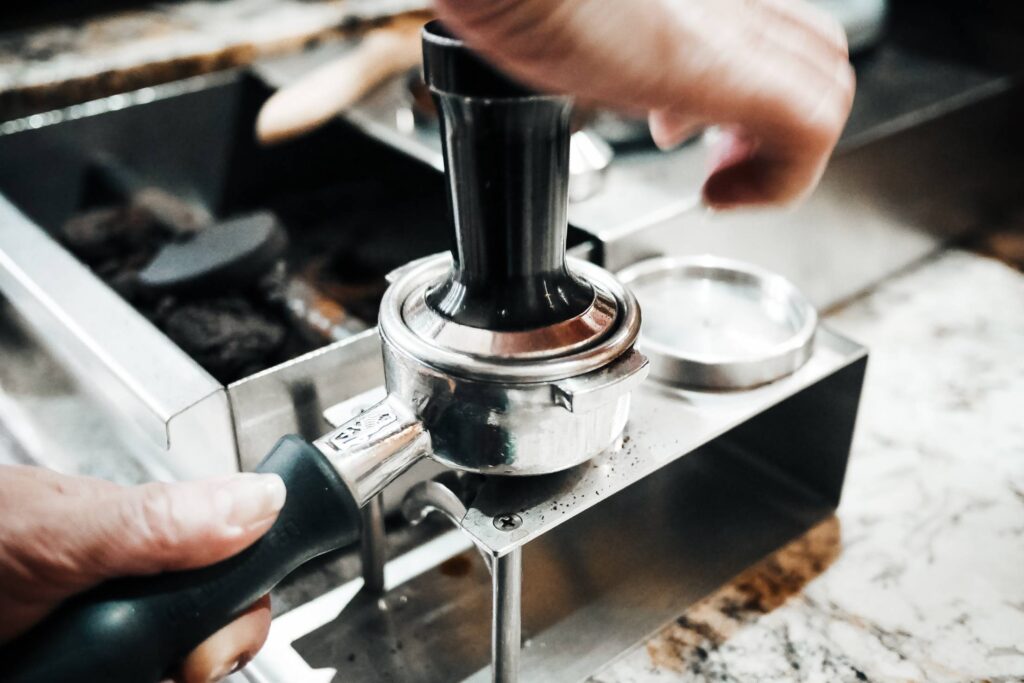 Barista is Pressing Ground Coffee in the Cafe Shop Free Photo