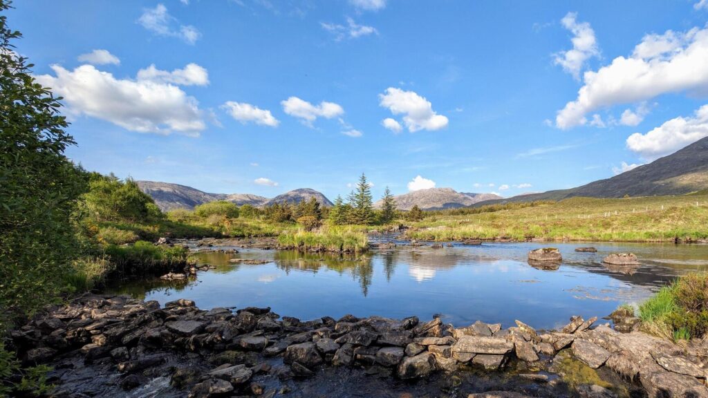 Beautiful landscape scenery, river with mountains and pine trees reflection, nature background Derryclare natural reserve at Connemara national park, county Galway, Ireland, wallpaper Stock Free