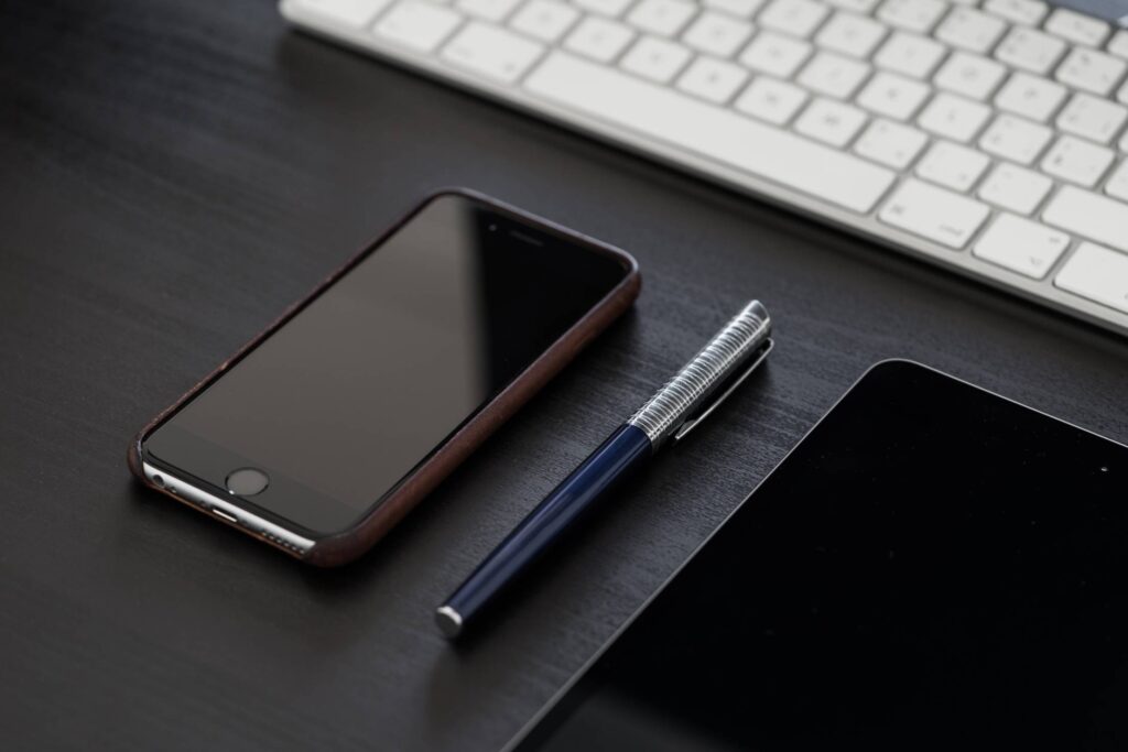 Black iPhone on Black Office Desk Free Photo