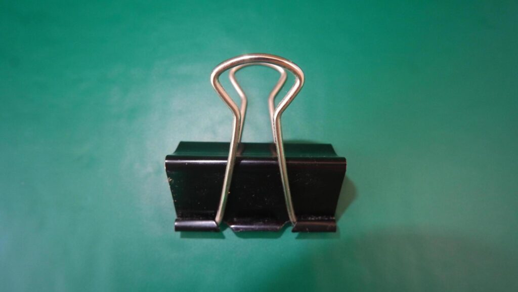 photo black paperclip on green background Stock Free