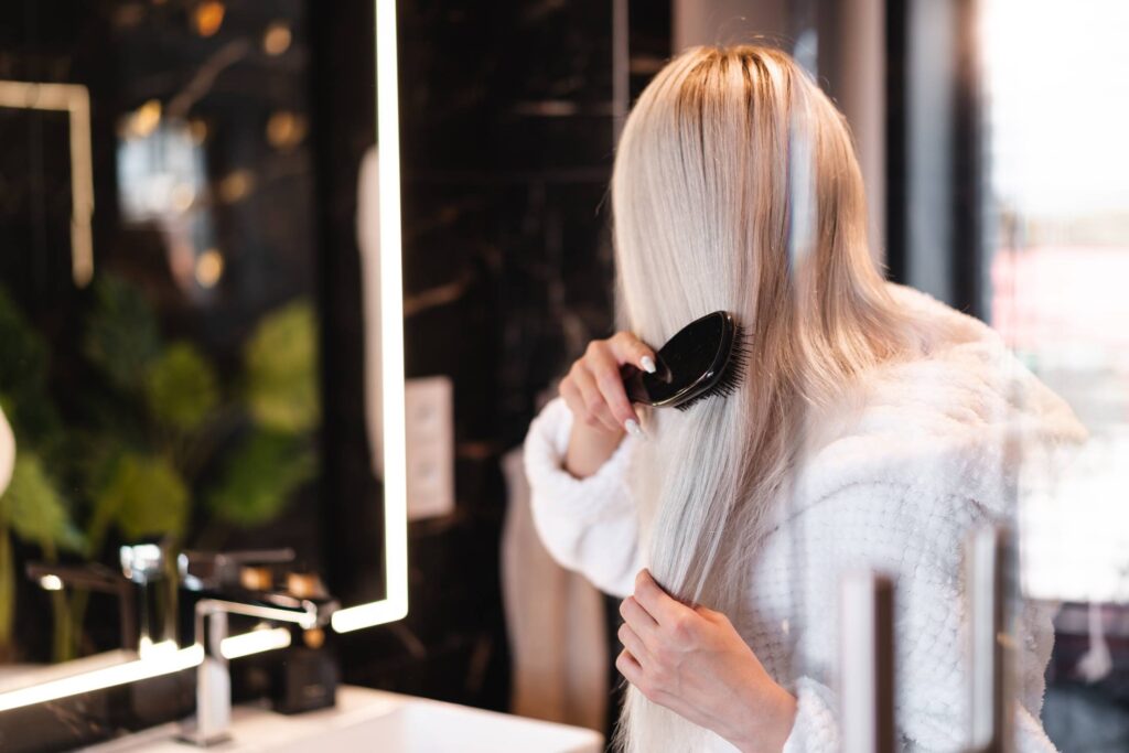 Blonde Woman Brushing Her Hair Free Photo