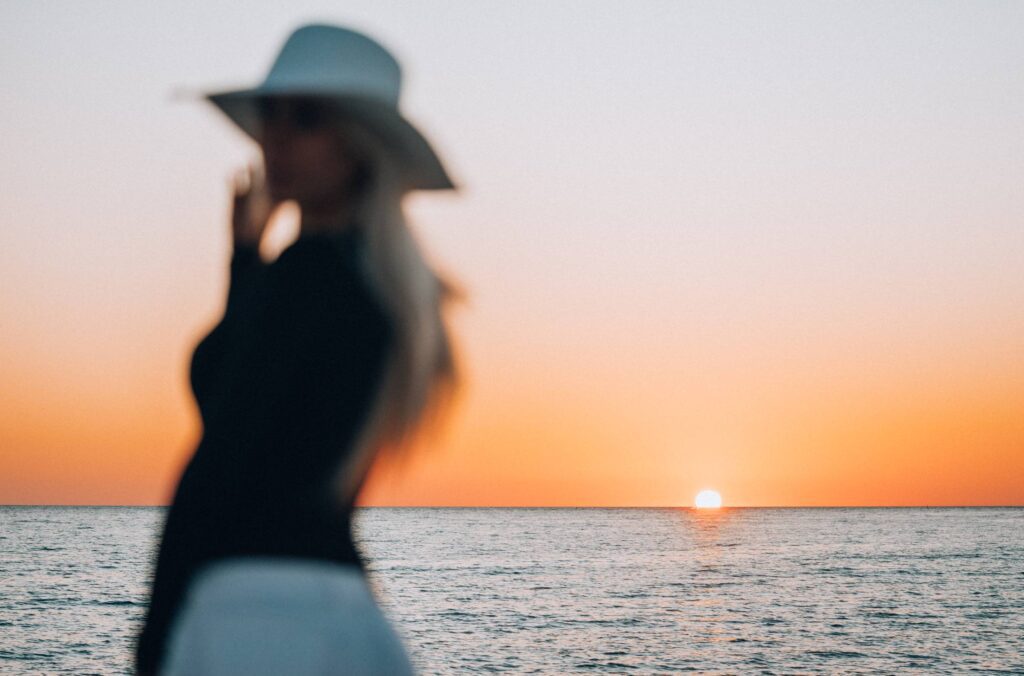 Blurred Silhouette of a Woman Enjoying Sunset by The Sea Free Photo