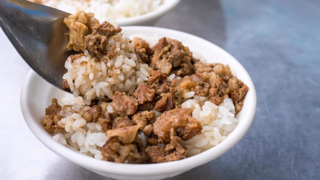 Braised meat rice, stewed beef over cooked rice in Tainan, Taiwan. Taiwanese famous traditional street food delicacy. Travel design concept, closeup. Stock Free