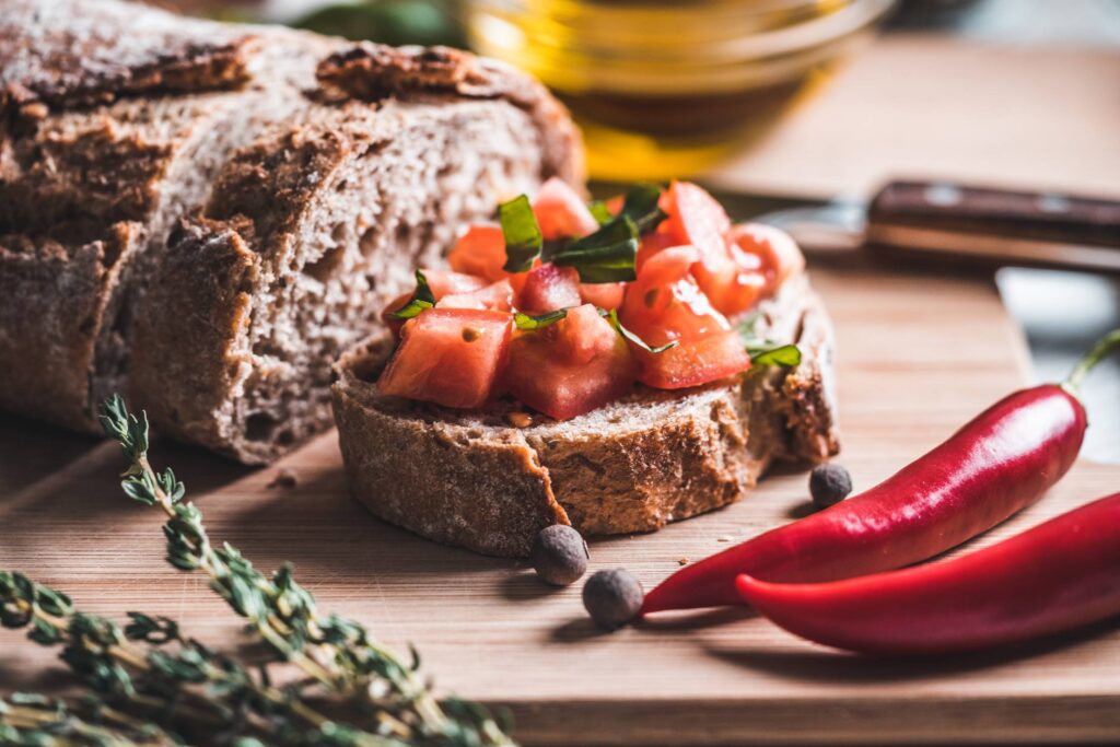 Bread with Tomatoes and Basil on The Chopping Board Free Photo