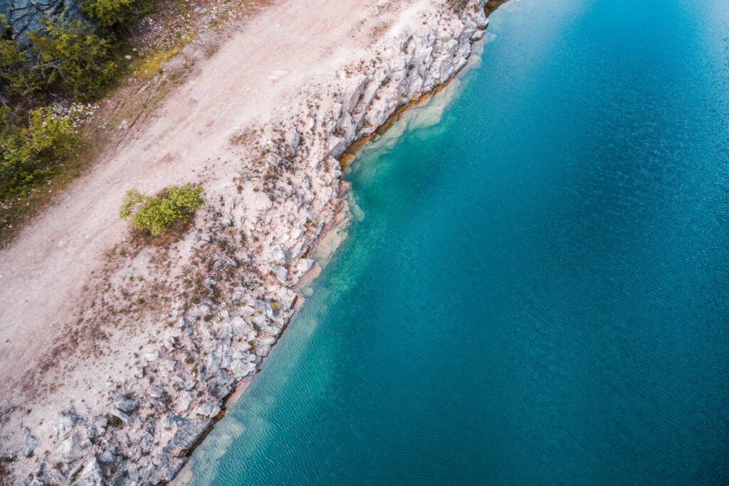 Bright Blue Water and Rocky Shore Free Photo