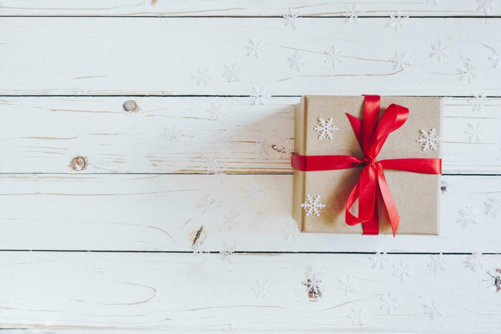 Brown gift box and Christmas presents on white wooden table background. Stock Free