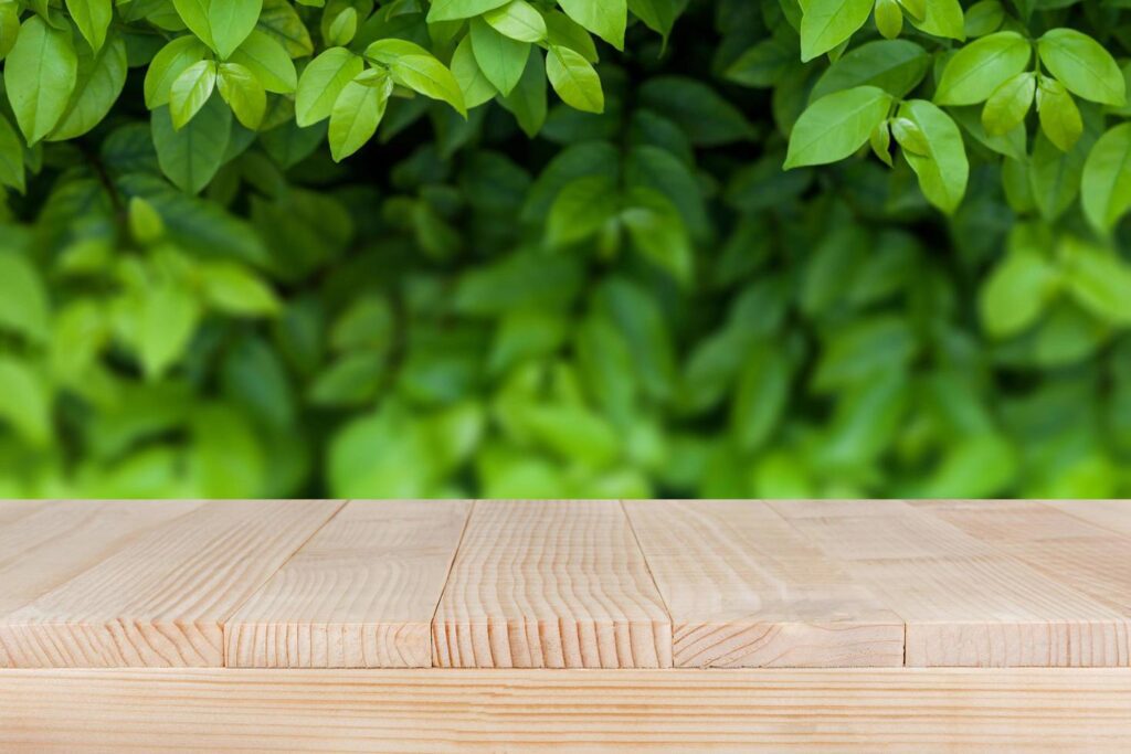 brown wood table top on bokeh abstract green nature background – can be used for montage or display your products Stock Free
