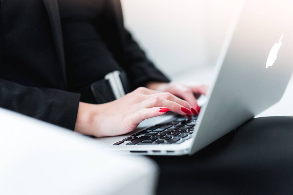 Business Woman Typing on MacBook Free Photo