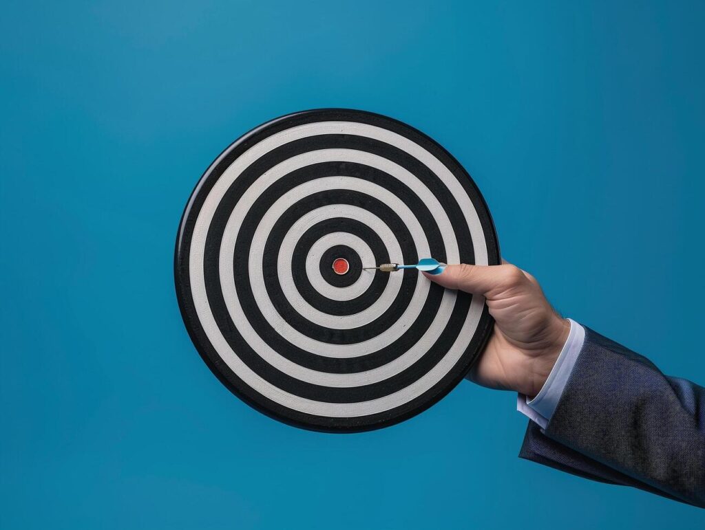 Businessman holding a dart target, dartboard, business goal concept. Stock Free