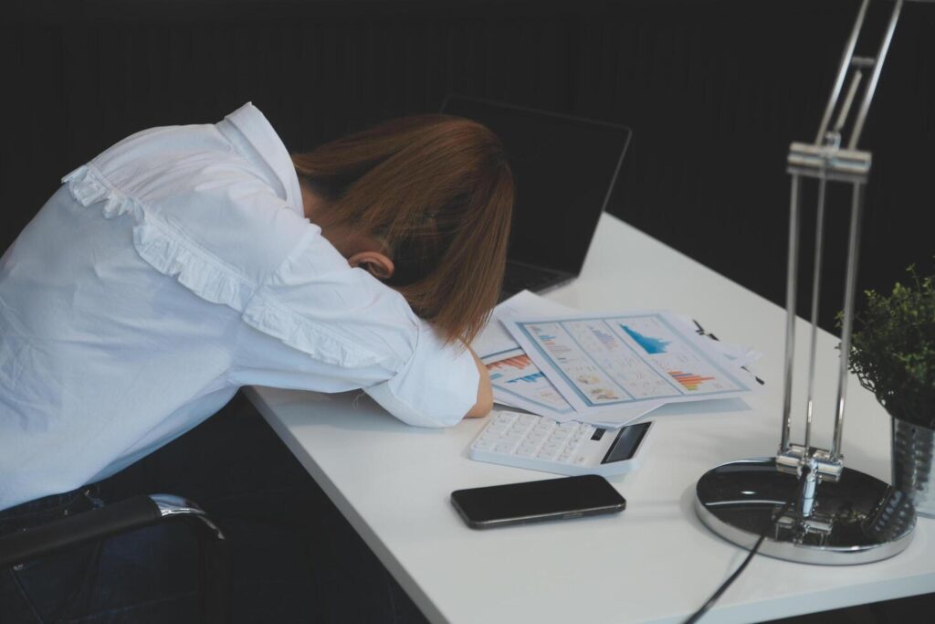 Businesswoman yawning while working with a laptop computer in the office, a woman in casual office lifestyle concept. Stock Free