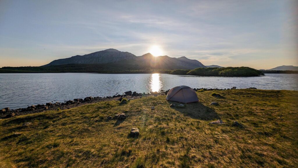 Camping tent by Lough Inagh, Connemara national park, county Galway, Ireland, lakeside landscape scenery with mountains in background, scenic nature wallpaper Stock Free