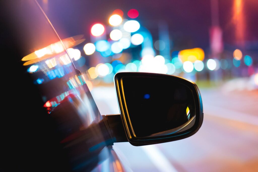 Car Side Rear-View Mirror with City Bokeh Lights Free Photo