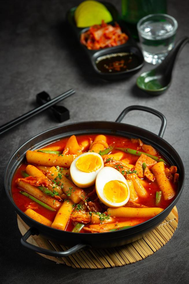 Cheesy Tokbokki korean traditional food on black board background. Lunch dish. Stock Free