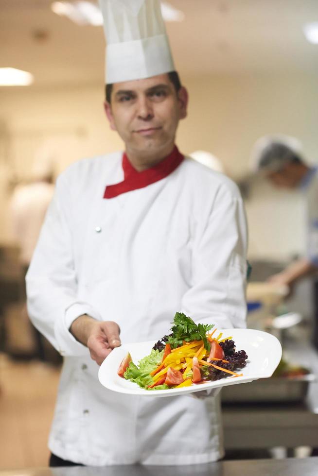 chef in hotel kitchen preparing and decorating food Stock Free