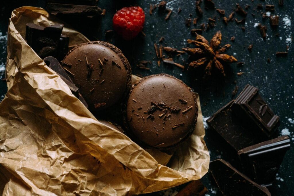 chocolate macarons with raspberry and chocolate on a dark background Stock Free