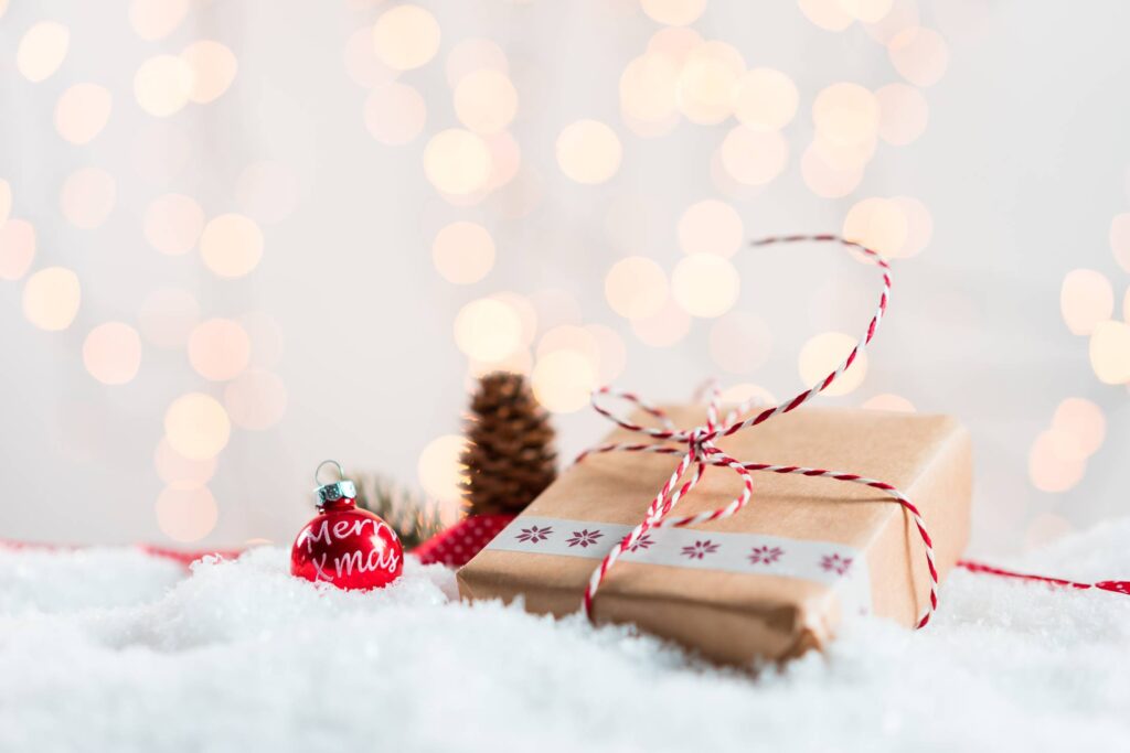 Christmas Present in Snow with Bokeh Background Free Photo