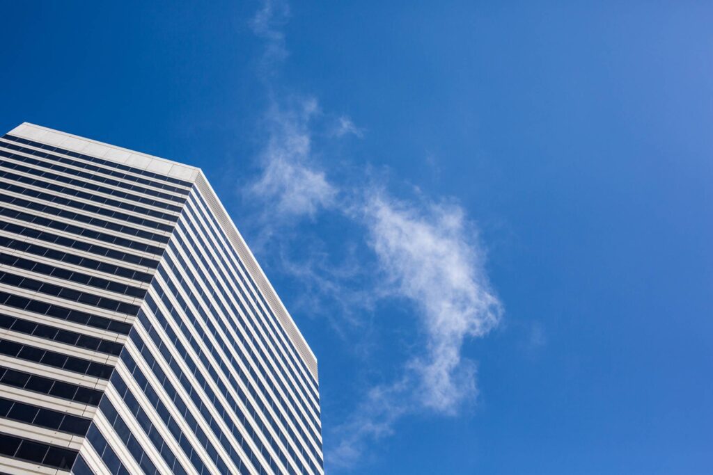 Clean Skyscraper View from Below Against a Blue Sky Free Photo