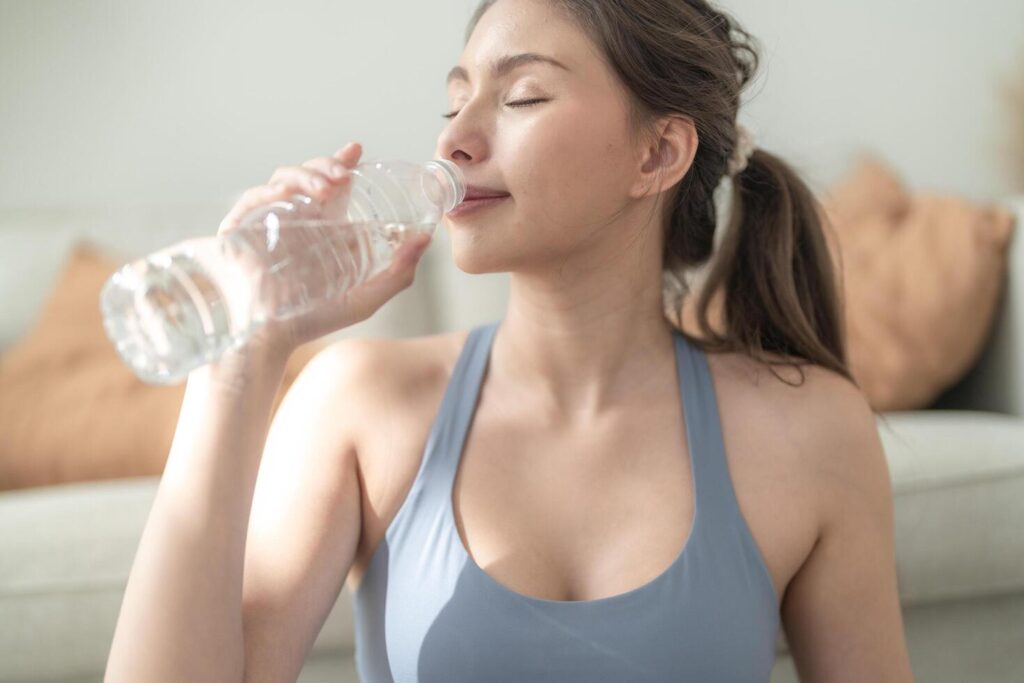 close up of Young face caucasian fitness woman wearing sport clothes training indoor drinking fresh water. healthy lifestyle and wellness. Stock Free