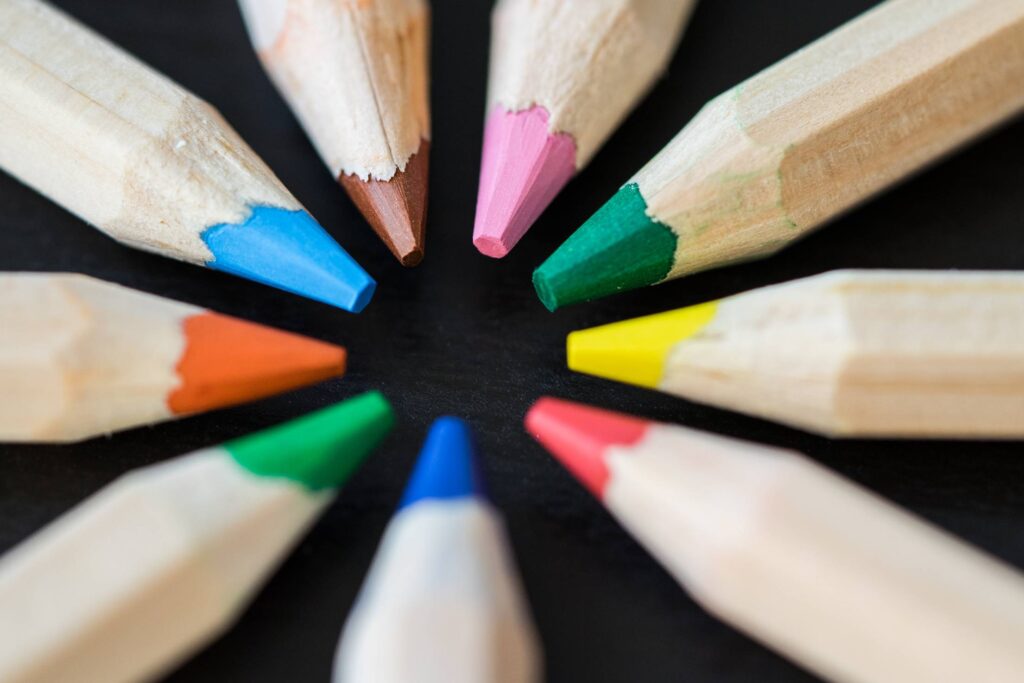 Colored Pencils in a Circle on a Black Desk Free Photo