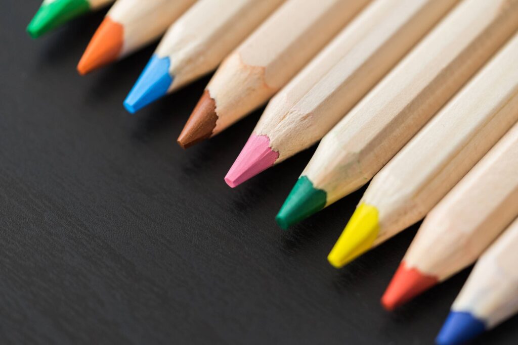 Colored Pencils in a Row on Black Desk Close Up Free Photo