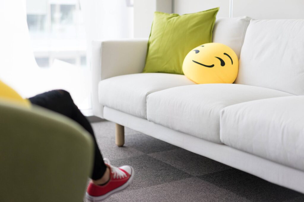 Colorful and Funny Pillows on Sofa in Modern Startup Office Free Photo