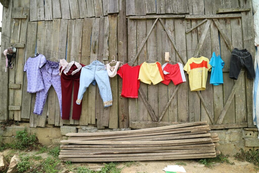 Colorful clothes hanging on a wire on a wooden wall. rural life style. family concept Stock Free