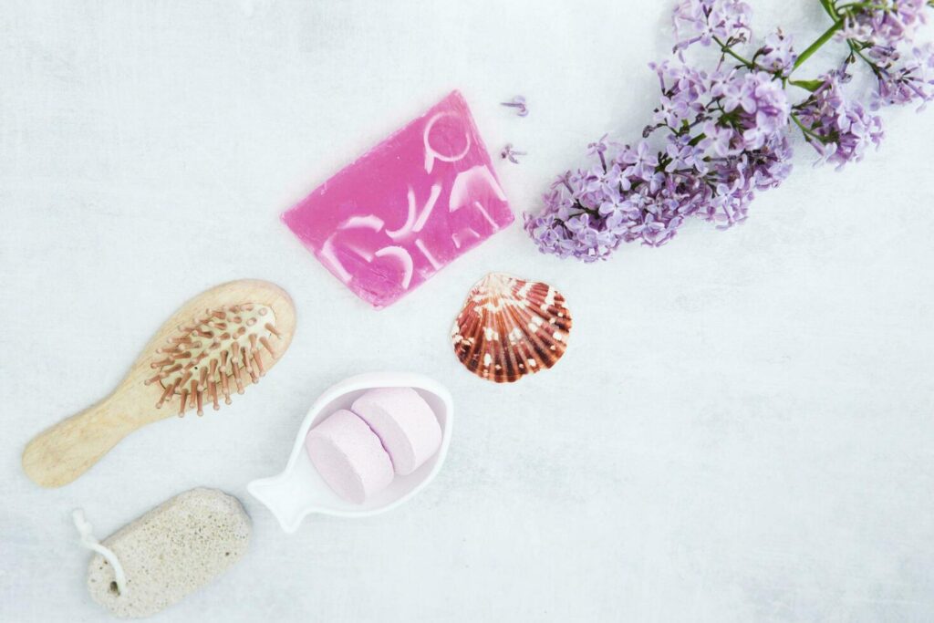 Concept of Spa-cosmetic and cosmetic procedures. Bath salt in effervescent tablets and handmade soap with lilac flowers on light concrete background. The concept of a waste-free lifestyle. Stock Free