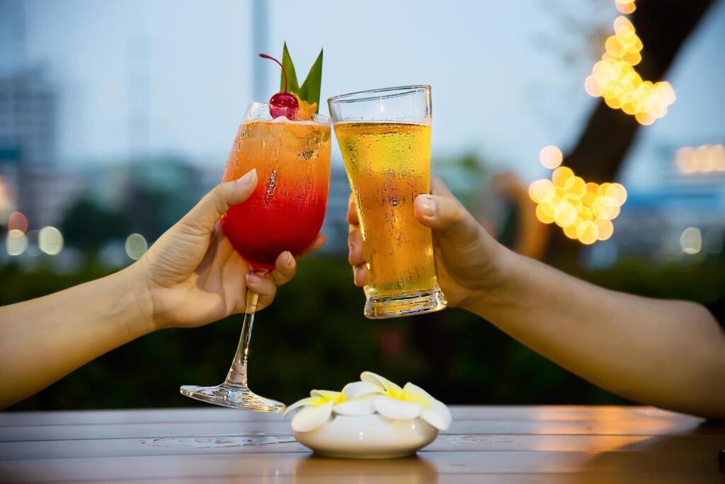 Couple celebration in restaurant with soft drink beer and mai tai or mai thai – happy lifestyle people with soft drink concept Stock Free