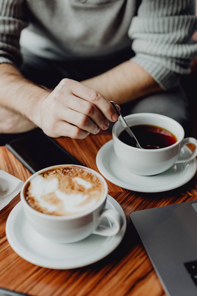 Cup of Cappuccino and Tea Business Meeting in Café Free Photo