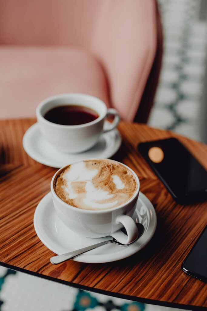 Cup of Cappuccino and Tea During a Creative Business Meet in a Café Free Photo