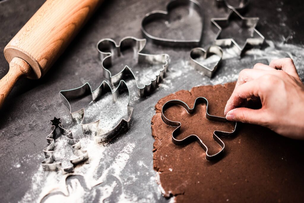 Cutting Gingerbread Man at Christmas Free Photo