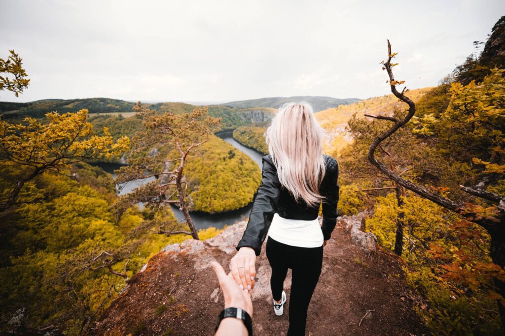 Daredevil Couple Exploring a Dangerous Edge of the Rock Free Photo