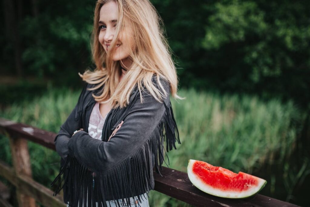 Blonde woman having a healthy snack at the wooden pier Stock Free