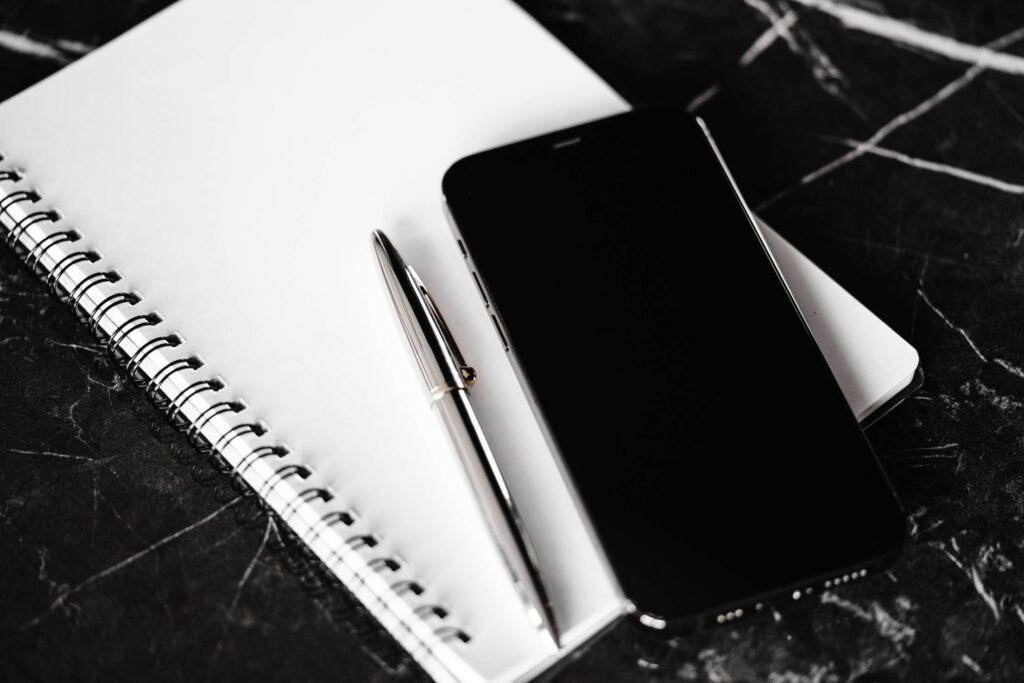 Diary, Silver Pen and Smartphone on Black Marble Table Free Photo