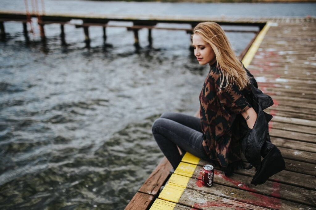 Beautiful blonde woman on a wooden pier by the lake Stock Free