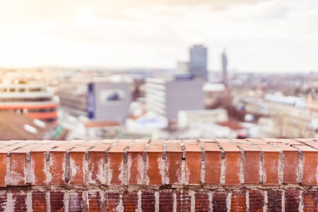 Empty Brick Wall with Blurred City View Background Free Photo