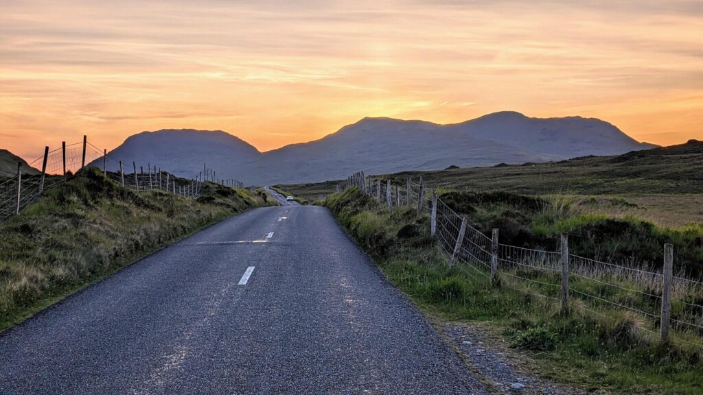 Empty scenic road trough nature and mountains at sunset, Inagh valley, Connemara, Galway, Ireland, landscape background, wallpaper Stock Free