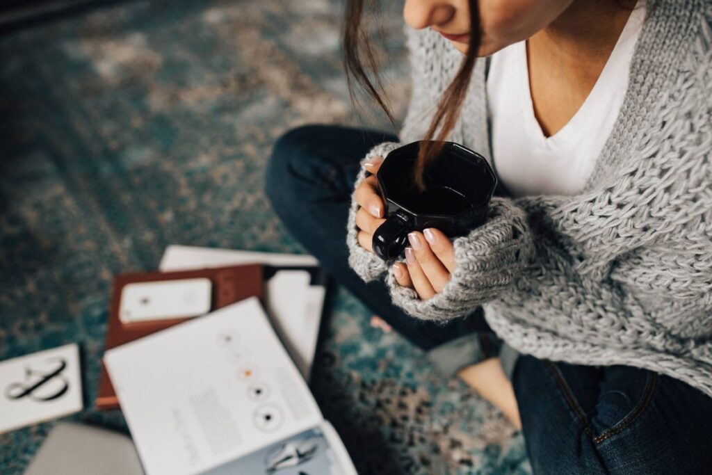 Woman reading magazines on the floor while enjoying her cup of tea Stock Free