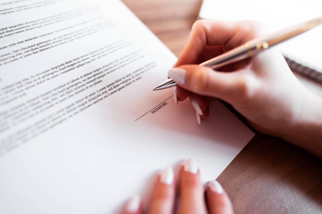 Female Hand Signing Insurance Contract Free Photo